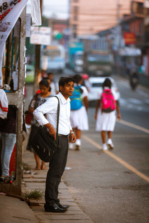 Ambalangoda, Sri Lanka - 02 February, 2017: Regular public Sri Lankan bus stop. Moring traffic in the city. People wait for the bus to work. Children students go to schoolのeditorial素材