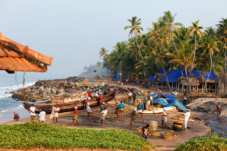 Varkala, India - February 09, 2016: Fishing net with many fishermen on backside the boat. Odayam beach, Varkala, Indiaのeditorial素材
