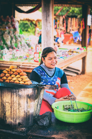 Sihanoukville, Cambodia - January 18, 2015: Street Market with food and souvenirs. Happy female seller. Kbal Chhay Waterfalls near Sihanoukville, Cambodia. Cambodian people love to rest in Bungalows near waterfallのeditorial素材