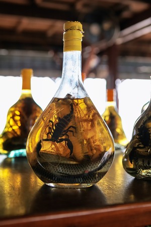 Asian Souvenir shop market stall with bottles of snake and scorpio alchohol tincture sold in souvenir in Cambodian shop market stallの写真素材