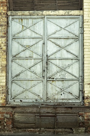 Grunge dirty old rusty closed metal door in typical St. Petersburg backyardの写真素材