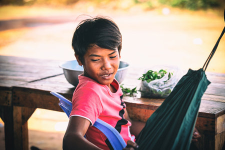 Sihanoukville, Cambodia - January 18, 2015: Cambodianboy cooks in slum village near Otres Beach in Sihanoukville, Cambodiaのeditorial素材