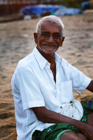 Varkala, India - February 09, 2016: Portrait of happy Indian fisherman unravels fishing nets and tackle while sitting in a boat, Kerala India Fishery Gulf. Odayam beach, Varkala, Indiaのeditorial素材