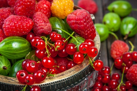 Mix of fresh organic garden berries isolated on wooden table background closeup