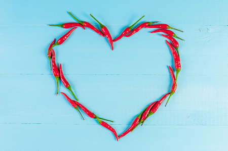 Red hot chili peppers on old blue wooden tableの写真素材