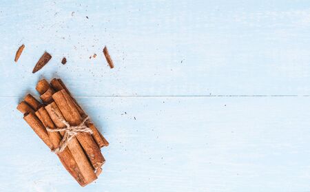 Ground cinnamon, cinnamon sticks, tied with jute rope on old wooden background in rustic style selective focusの写真素材