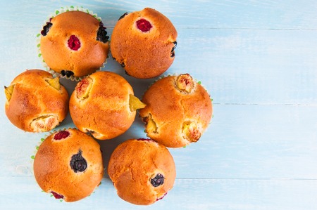 Blueberry and raspberry muffins with powdered sugar and fresh berries