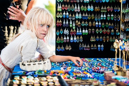 SEVASTOPOL, RUSSIA - SEPTEMBER 11, 2016: Little girl wearing white ancient slavic dress on Crimean Historical Festival in the sunny summer day looking to ancient jewerlyのeditorial素材