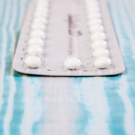 Contraceptive Pill with English Instructions.. Wooden vintage blue background, free space for text.