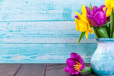fresh purple tulip, yellow flowers close up on wooden background Bouquet snowdrops on wooden...