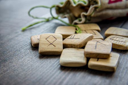 Ancient runes, canvas bag with embroidery on old vintage wooden background. Selective focus.の写真素材
