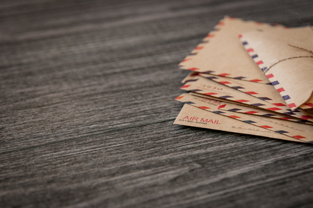 Old vintage retro envelopes with a wax stamp on old dark brown wooden tableの写真素材