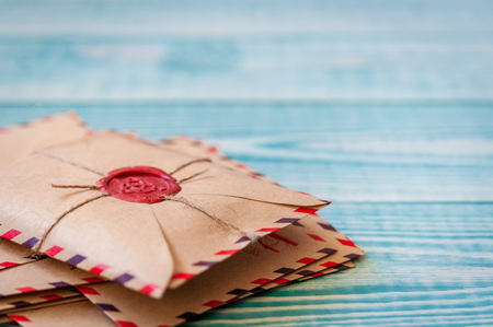 Old vintage retro envelopes with a wax stamp on old blue wooden tableの写真素材