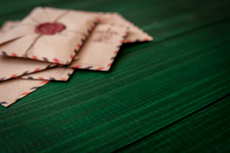 Old vintage retro envelopes with a wax stamp on old dark green wooden table