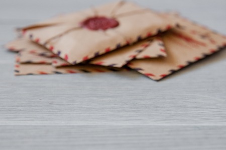 Old vintage retro envelopes with a wax stamp on old white wooden tableの写真素材