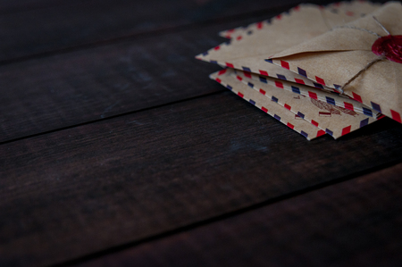 Old vintage retro envelopes with a wax stamp on old dark brown wooden tableの写真素材