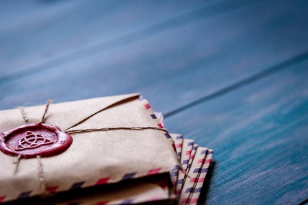Old vintage retro envelopes with a wax stamp on old blue wooden table