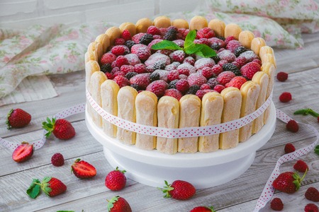 The summer biscuit naked bargaining with cream and fresh berries on a wooden background.の写真素材