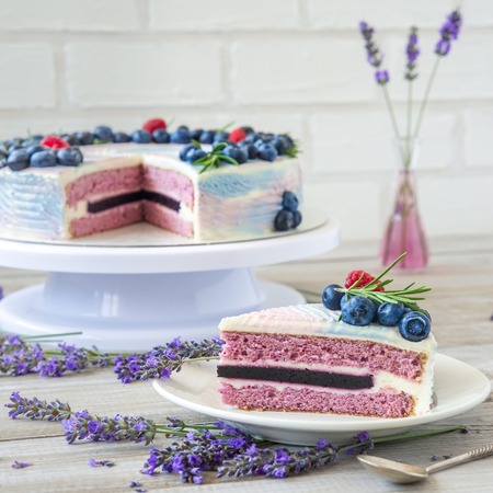Lavender cake whit berries and flowers on a wooden background. Natiral light, natural colorsの写真素材