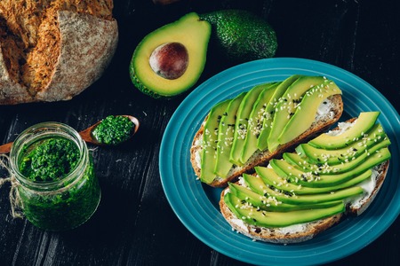 Avocado sandwich on dark rye bread made with fresh sliced avocados from above.の写真素材