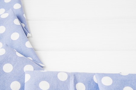Light violet blue polka dots folded tablecloth over bleached wooden table. Top view image. Copyspace for your textの写真素材