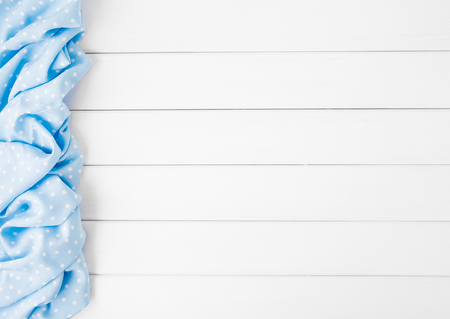 Light blue polka dots folded tablecloth over bleached wooden table. Top view image. Copyspace for your textの写真素材
