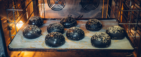 fresh loaf black Burger with sesame seeds in the oven.の写真素材