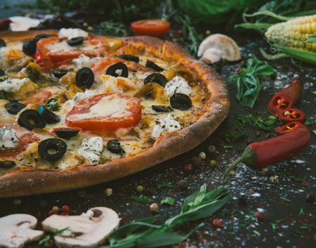 Tasty seafood pizza with cherries on a wooden table.の写真素材