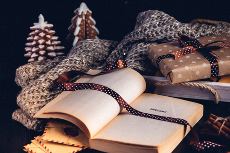 Gingerbread christmas tree cookies, opened book with the inscription on the page January.Sparklers and gift in a box.の写真素材