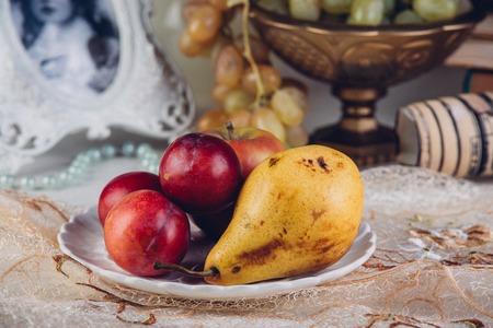 Seasonal fruits pears and plums in a rustic plate.の写真素材