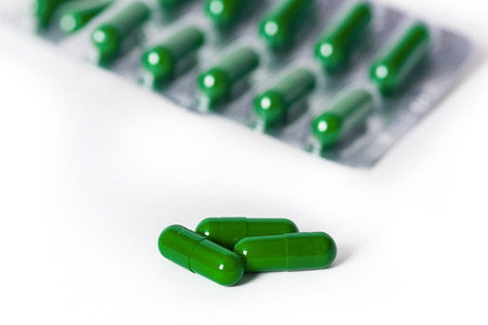 group of capsule pills spirulina with green color on white background.の写真素材