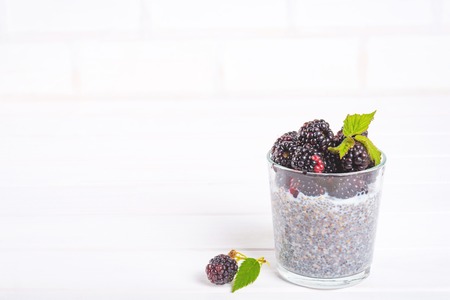 Food and drink, healthy eating and dieting concept. Homemade white chia pudding with fresh berries and green leaves for breakfast on a light kitchen table. Copy spaceの写真素材