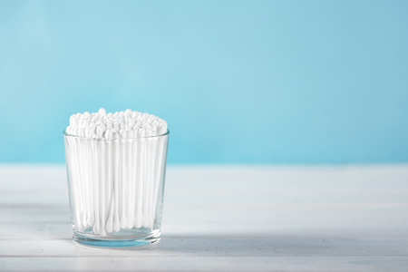Cotton swabs in clear glass jar on pastel blue background. Copy spaceの写真素材