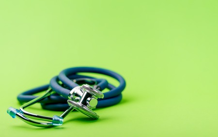 Selective focus of blue stethoscope on green background. For check heart or health check up concept. Copy space.の写真素材
