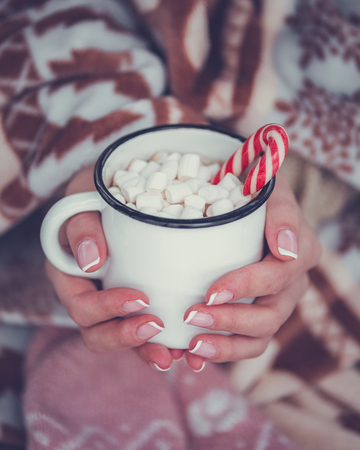 Hot chocolate with marshmallow in woman hand and sweater.の写真素材