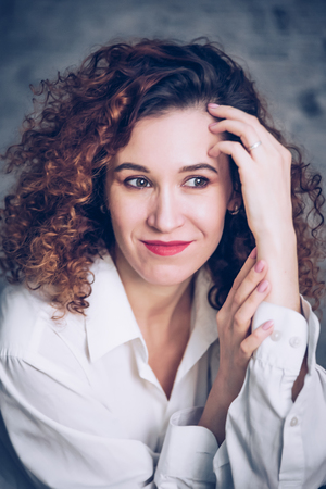 Young woman with brunette curly hair, fashionable toning.の写真素材