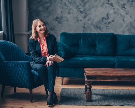 Beautiful young caucasian European woman sitting in an armchair.の写真素材