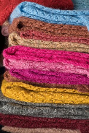 Texture of warm, pastel clothes and knitted scarves on a whiteの写真素材