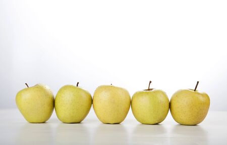 yellow apple row on white backgroundの写真素材