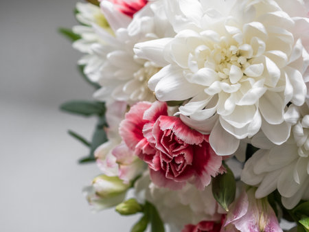 Bouquet close-up. Bouquet of white chrysanthemums, red carnations and eucalyptus leaves. On the windowsill by the window. copy spaceの写真素材