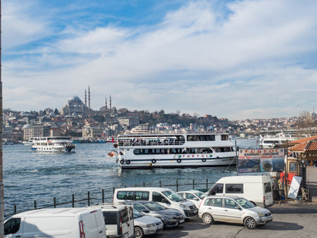 View of the bay on January 21, 2022 from the Galata Bridge in Istanbul, Turkey. The ship is sailing on the sea. On the shore in the port, there are cars. Sunny morning in Istanbulのeditorial素材