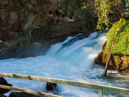 Observation platform for watching the mountain river. The rapid flow of the river creates rapids and a small waterfall.の写真素材