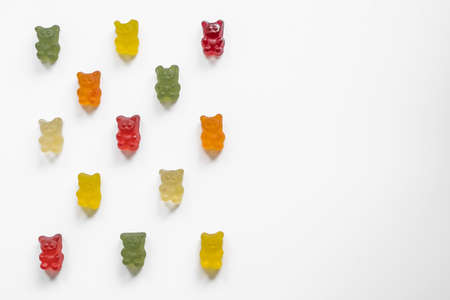 gummy bears laid out in rows in a checkerboard pattern on a light background, top viewの写真素材