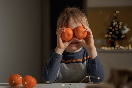 the boy put tangerines to his eyesの写真素材