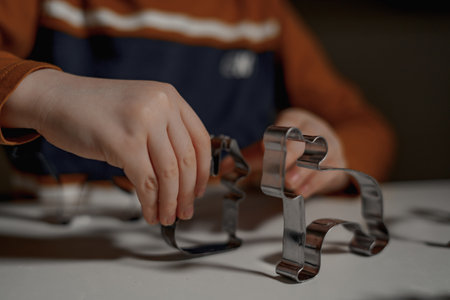 Children's hands hold metal molds for Christmas cookiesの写真素材
