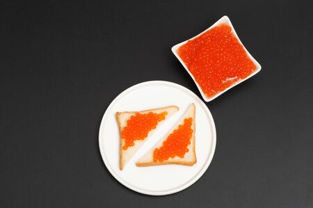 Red caviar in a saucer on a black backgroundの写真素材