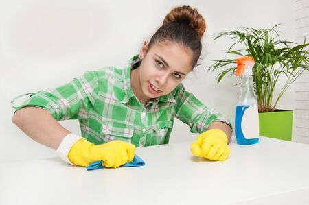 Girl in gloves cleans the apartment