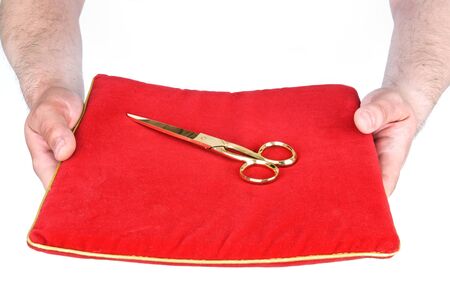 Golden scissors on a red pillowの写真素材