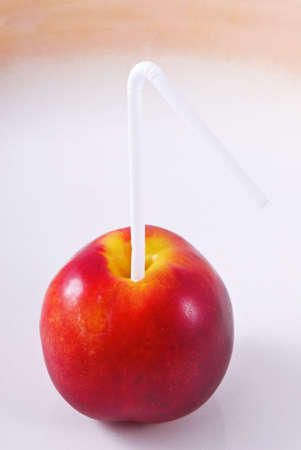 Nectarine with a straw. Nectarine Juice. Creative.の写真素材