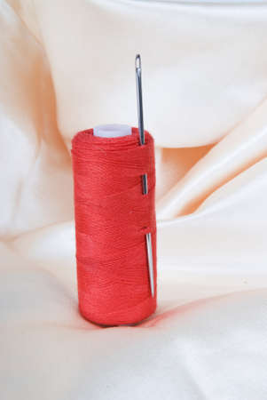 Spool of red thread with a needleの写真素材